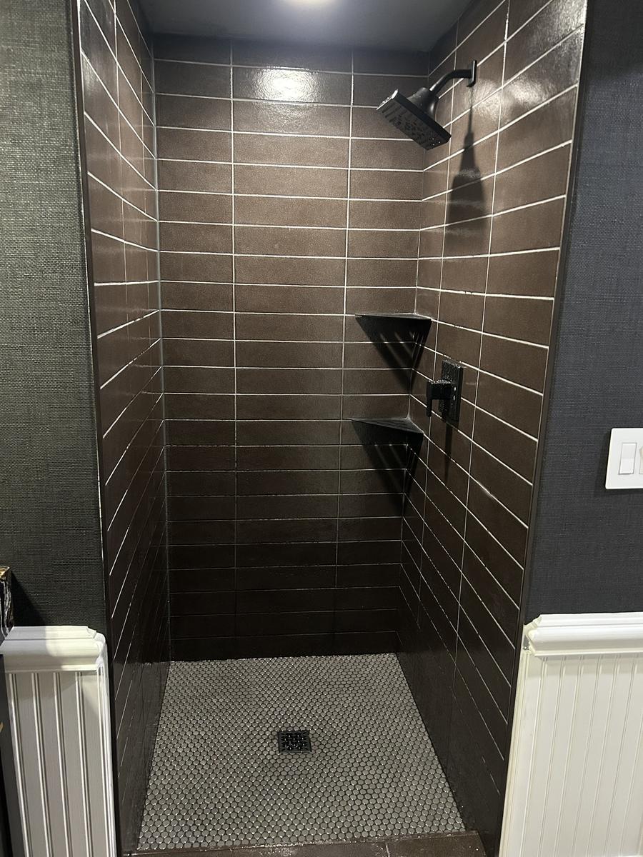 Finished custom tile walk-in shower with black fixtures